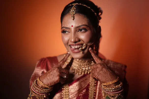 Bridal artist Odisha — smiling bride with nath and gold jewellery by Romma